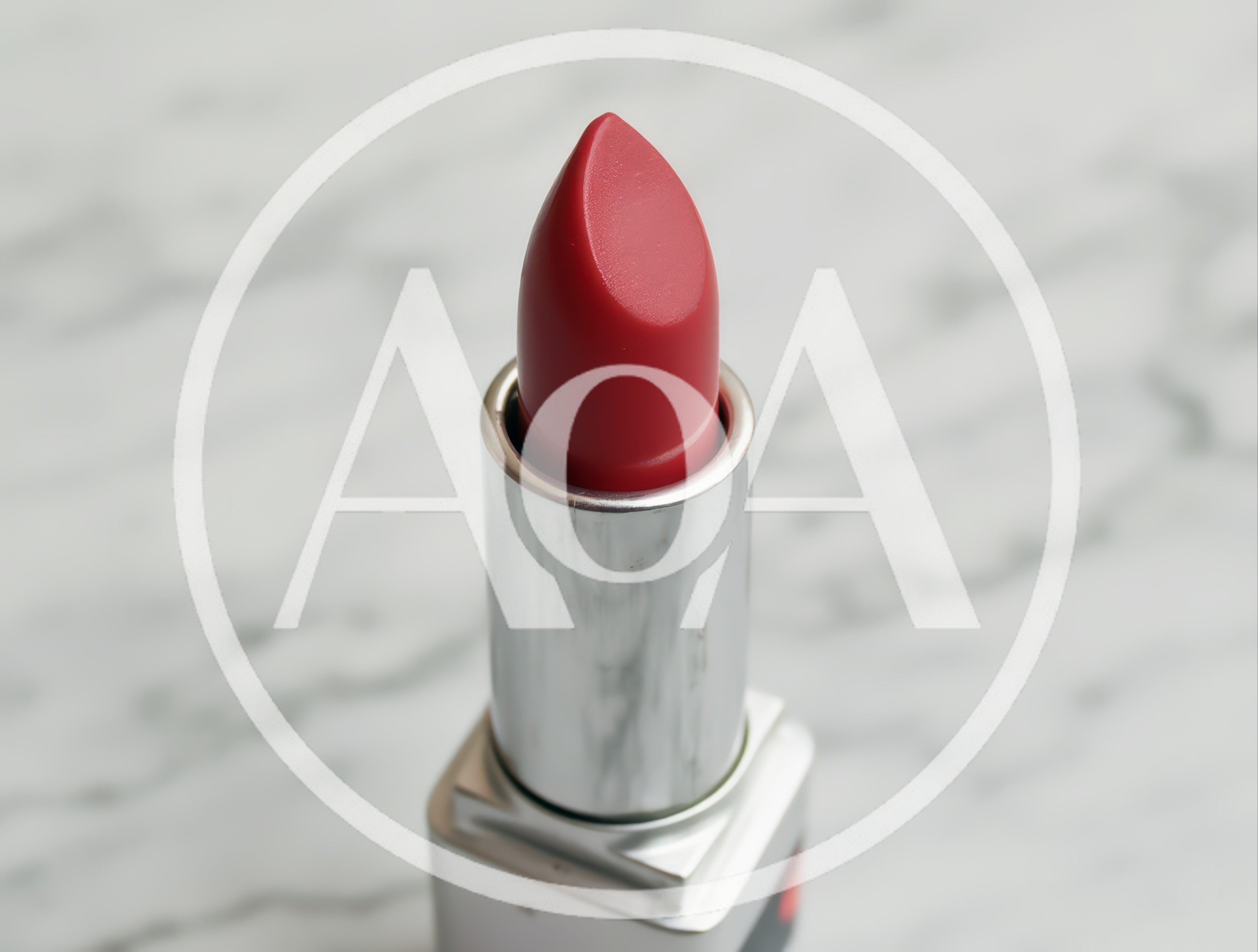 Red Lipstick Tube Standing On Marble Surface