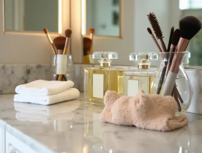 Luxury Perfume Bottles and Makeup Brushes on Marble Vanity