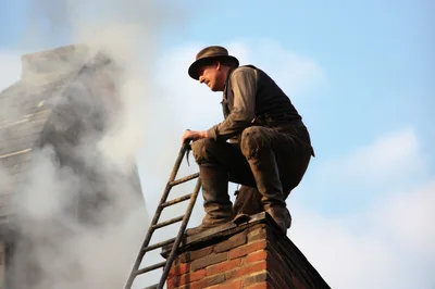Chimney Sweep Working On A Rooftop