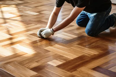 Professional Worker Installing Herringbone Hardwood Flooring