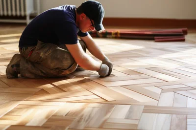 Professional Carpenter Installing Herringbone Hardwood Flooring