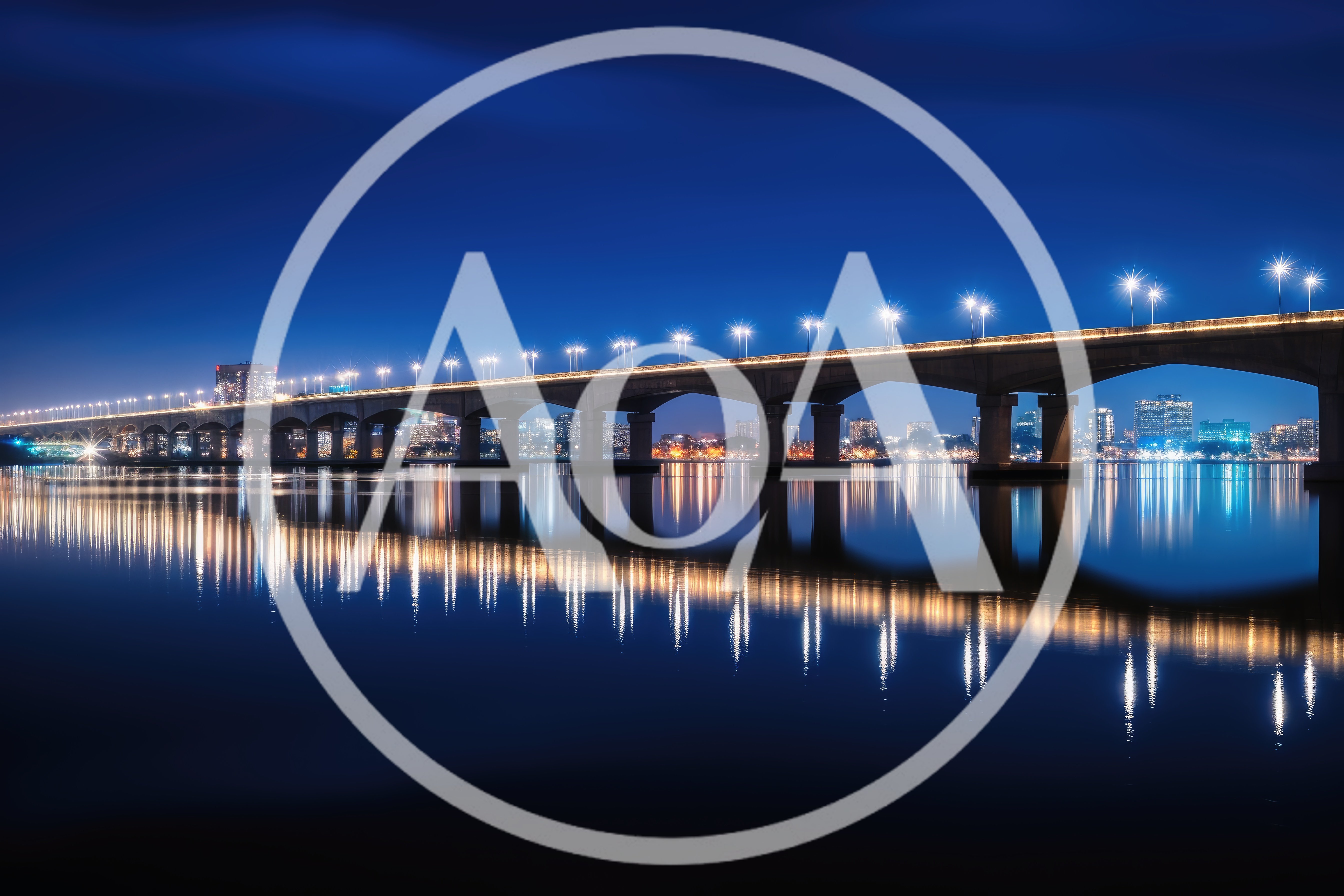 Illuminated Bridge Over Calm Water At Night
