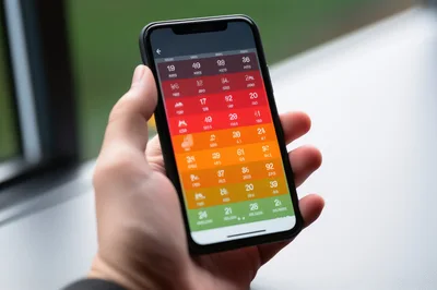 Hand Holding Smartphone Displaying Colorful Calendar App