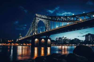 Illuminated Steel Truss Bridge Over River At Night
