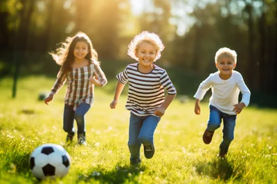 Three Happy Children Running Toward Soccer Ball