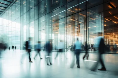 Blurred Business Professionals Walking Through Modern Glass Office Lobby