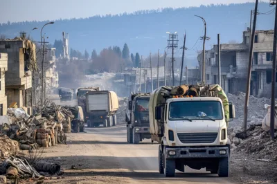 Military Convoy Driving Through War Torn City Ruins