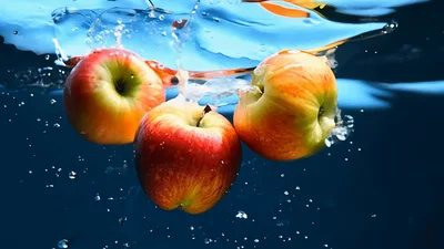 Three Fresh Red Apples Falling Into Clear Water