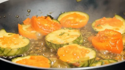 Sautéing Zucchini And Tomato Slices In A Pan