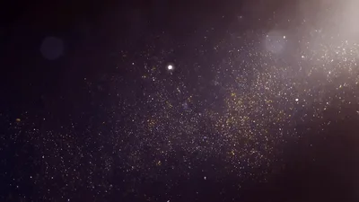 Golden Dust Particles Floating In Dark Background