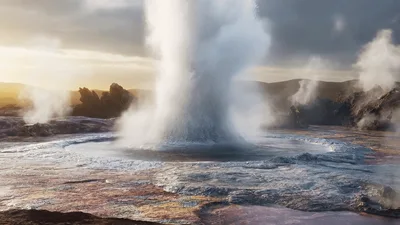 Powerful Geyser Erupting In Volcanic Landscape