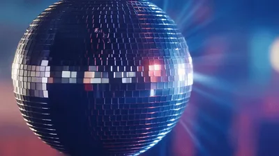 Rotating Disco Ball Reflecting Colorful Lights In Nightclub