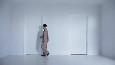 Person In Beige Suit Walking And Opening A Door