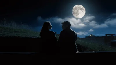 Couple Sitting Together Under A Full Moon