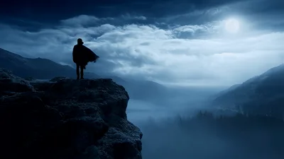 Lone Traveler Standing On A Misty Mountain Cliff