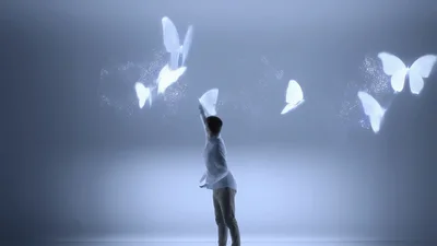 Man Interacting With Glowing Digital Butterflies In Studio