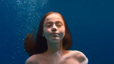 Young Woman With Red Hair Floating Underwater