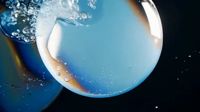 Two Iridescent Soap Bubbles Colliding And Merging