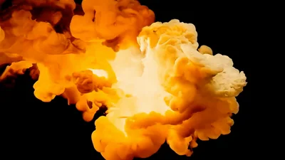 Orange Smoke Cloud Expanding Against Black Background