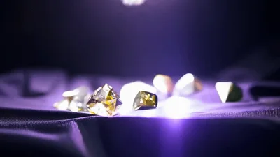 Colorful Gemstones Falling Onto Dark Purple Fabric