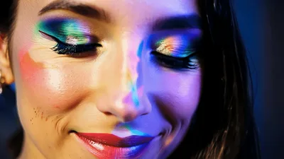 Woman With Rainbow Makeup Smiling At Camera