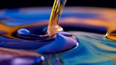 Golden Liquid Pouring Into Vibrant Colorful Viscous Pool