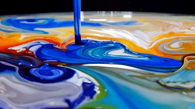 Vibrant Blue Paint Pouring Into Colorful Liquid Mixture