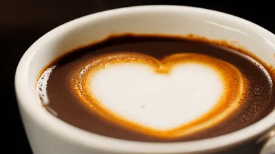 Pouring Steamed Milk Into Espresso To Create Heart Latte Art