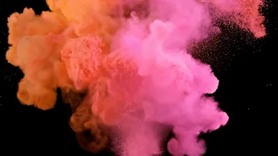 Pink and Orange Powder Explosion Against Black Background
