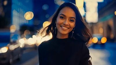 Smiling Woman Walking Through Busy City Street At Night
