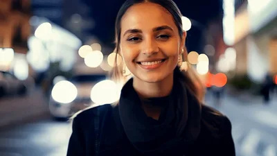 Young Woman Smiling At Camera On City Street
