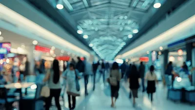 Blurred People Walking Through A Busy Modern Shopping Mall