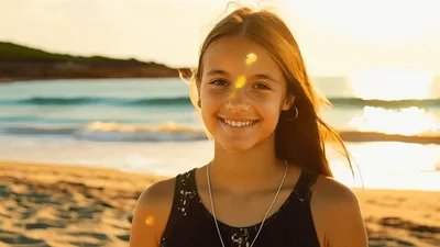 Portrait Of A Smiling Young Girl On The Beach