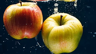 Two Fresh Apples Falling Into Clear Water