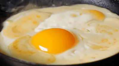 Adding Fresh Egg Yolk To Frying Pan