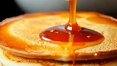Maple Syrup Pouring Over Stack Of Pancakes With Butter