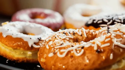 Assorted Glazed Donuts With Cream Filling On A Tray