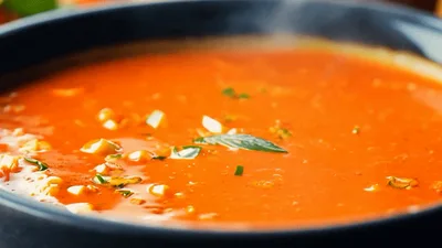 Ladle Pouring Fresh Tomato Soup Into A Bowl