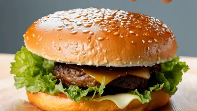 Hand Pressing Down On A Fresh Cheeseburger