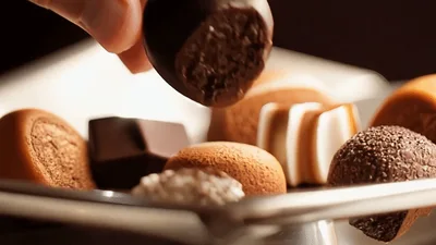 Hand Placing Dark Chocolate Truffle On A Platter