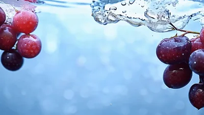 Red Grapes Falling Into Clear Water