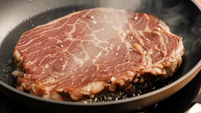 Raw Beef Steak Searing In A Hot Frying Pan