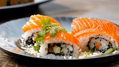Fresh Salmon Sushi Rolls Plated on Dark Ceramic Dish