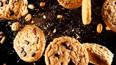 Chocolate Chip Cookies Falling Against Black Background