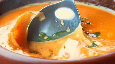 Spoon Stirring Creamy Tomato Soup In A Bowl