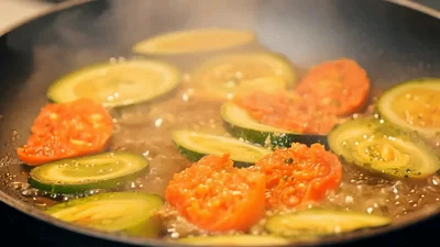 Sautéing Zucchini And Tomato Slices In A Frying Pan