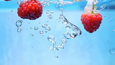 Fresh Raspberries Falling Into Clear Water With Bubbles