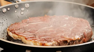 Raw Beef Steak Searing In A Hot Frying Pan
