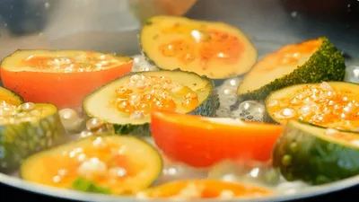 Sautéing Sliced Zucchini and Tomatoes in a Pan