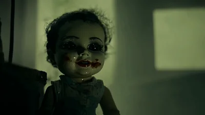 Creepy Doll With Bloody Face Sitting In Dark Room